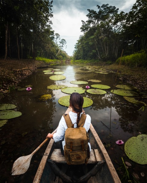 woman explorer travels amazon river canoe